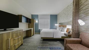 Une chambre d’hôtel avec un lit, une télévision, un bureau, une lampe et un canapé.