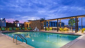 A swimming pool with lounge chairs and a covered seating area. - Home2 Suites By Hilton Guntersville (Guntersville)