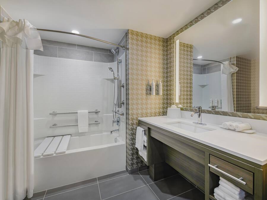 A modern bathroom with a walk-in shower, a double sink vanity, and a large mirror.