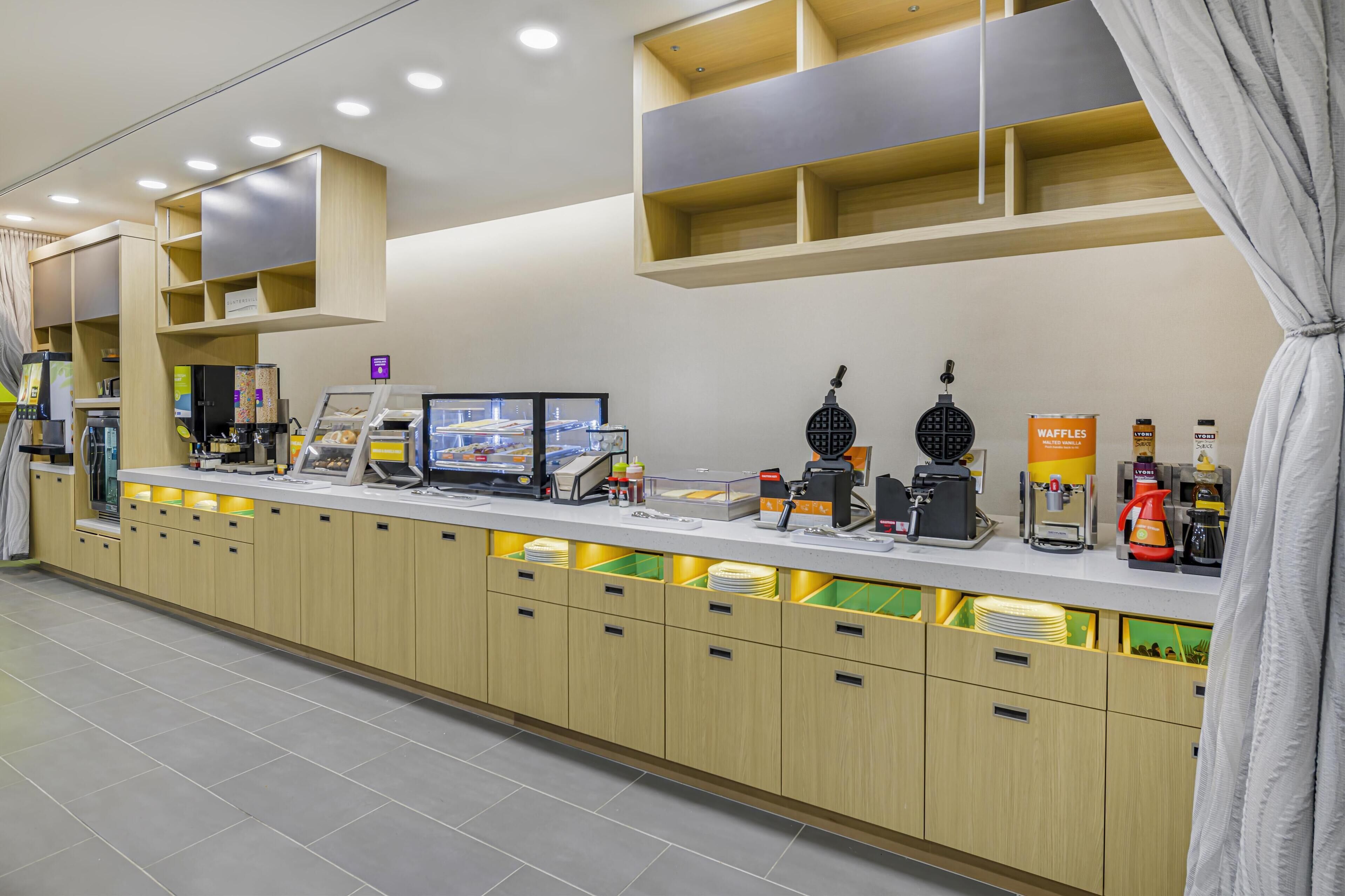 Een moderne keuken met inbouwapparatuur, een koffiehoek en een etalage.