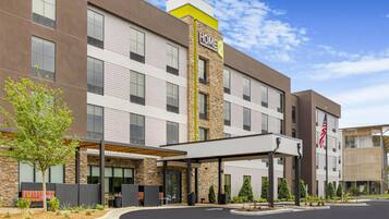 A modern hotel with a stone facade, multiple windows, and an American flag.