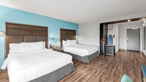 A hotel room with two beds, wooden flooring, and a blue accent wall. - Tru By Hilton Kansas City Airport (Kansas City)