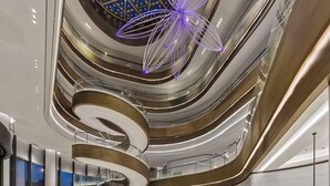 Un interior moderno con una escalera espiral central, varios niveles y una lámpara en forma de estrella.