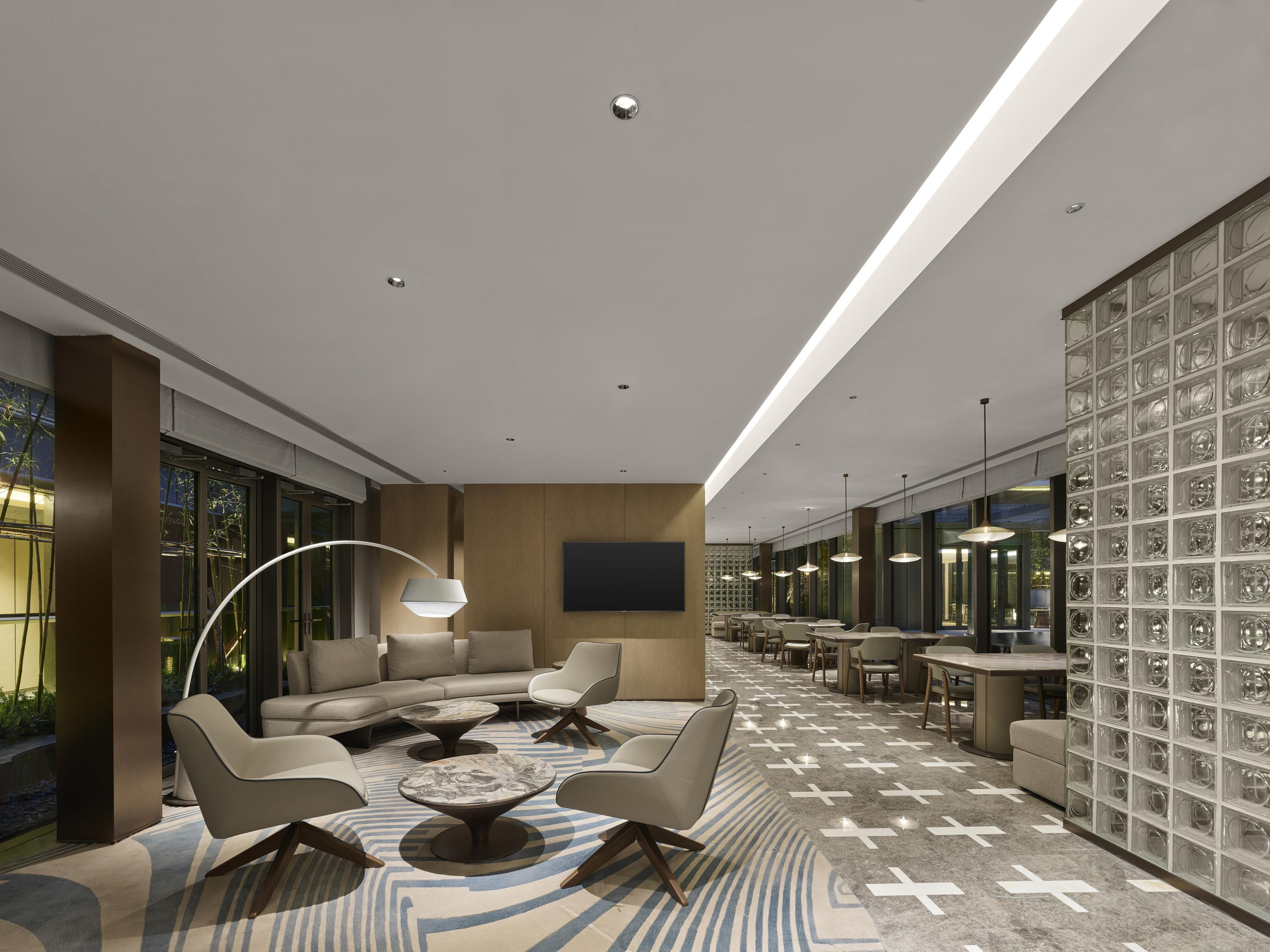 A modern lounge area with sofas, a coffee table, and pendant lighting.