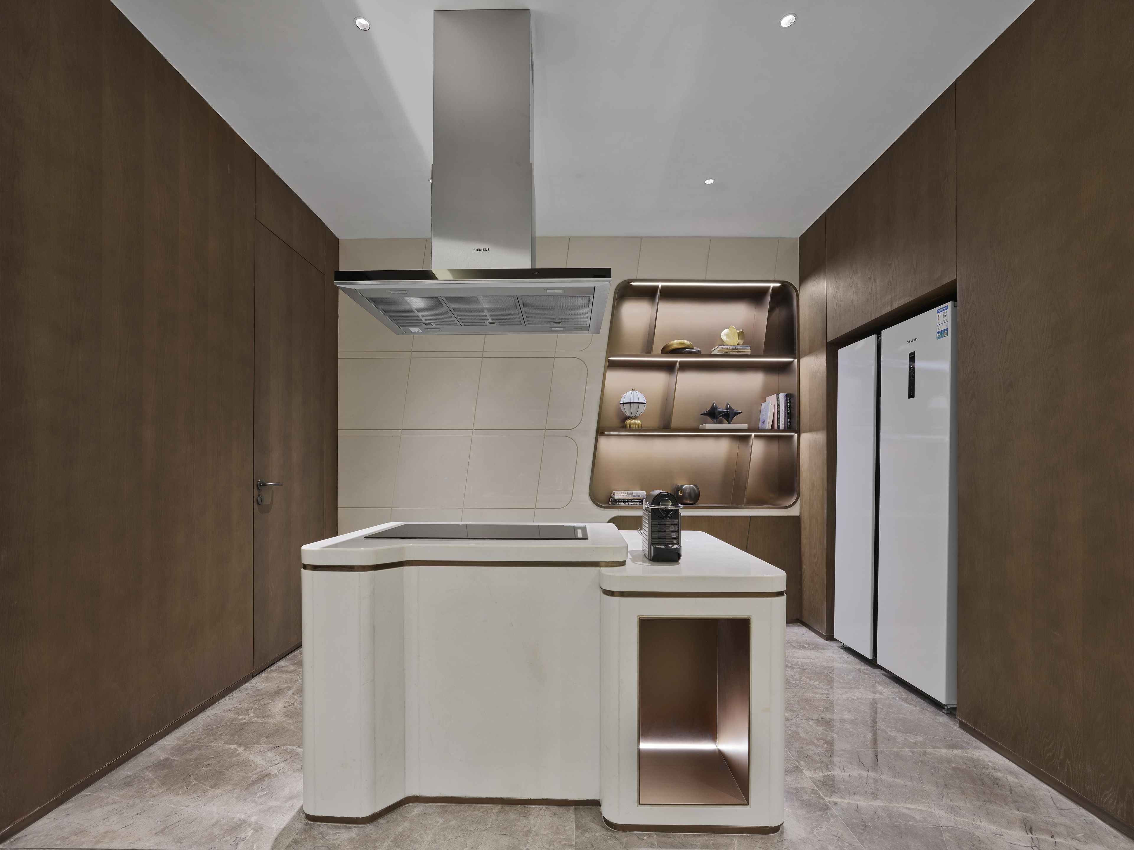 A modern kitchen with a built-in sink, a stainless steel range hood, and a wall-mounted shelf with decorative items.