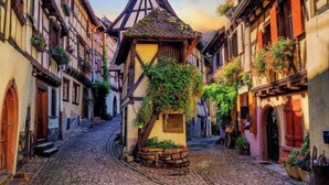 A cobblestone street lined with traditional half-timbered buildings, a central tower with a conical roof, and a small stone bench. - Black Forest Loft 1, Unique Home, View (Horben)