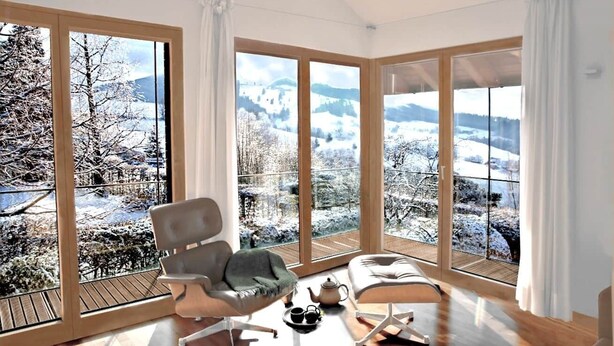 A modern room with large windows, a wooden floor, a chair, a table, and a teapot. - Black Forest Loft 1, Unique Home, View (Horben)