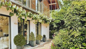 A modern building with large windows, a stone pathway, and various potted plants. - Black Forest Loft 1, Unique Home, View (Horben)