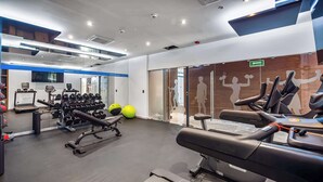 A modern gym with treadmills, weight machines, and exercise balls.