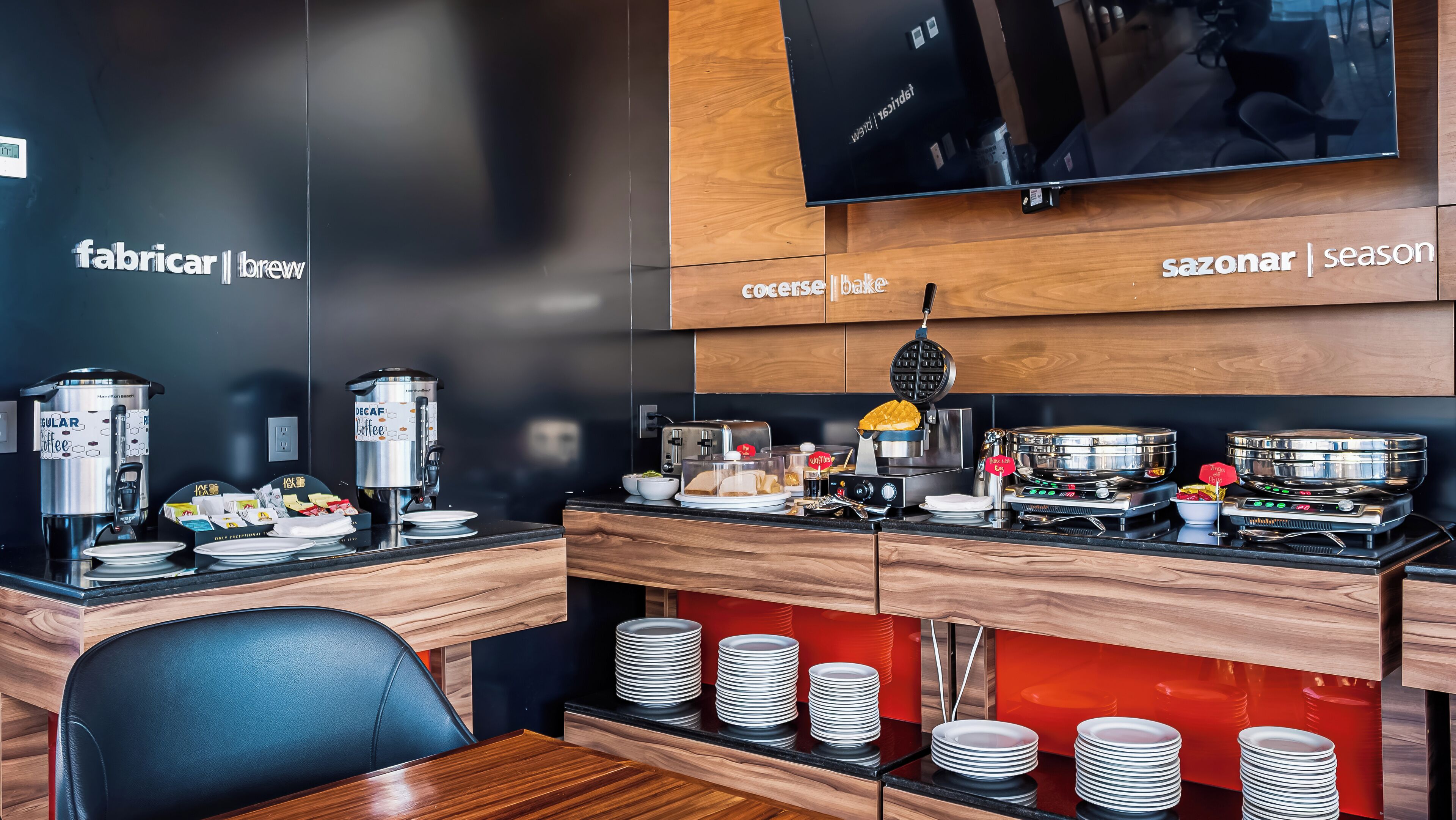 Une cuisine moderne équipée de machines à café, d’un appareil à gaufres et d’une cuisinière.
