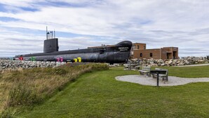 A submarine on display with a building labeled "ONONDAGA POLICE-ARS" in the background.