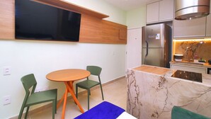 A modern kitchen with a built-in oven, a refrigerator, and a dining area with a table and chairs. - C061 (Rio de Janeiro)