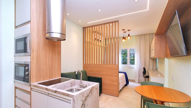A modern kitchen with a built-in oven, a sink, and a wooden partition. - C061 (Rio de Janeiro)
