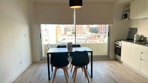 Eine moderne Küche mit Essbereich, großem Fenster und Blick auf die Stadt.
