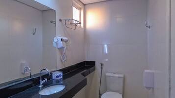A modern bathroom with a black countertop, a sink, a toilet, and a shower.