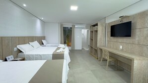A hotel room with two beds, a desk, a TV, and a wardrobe. - Pousada Recanto Dourado (Bonito)