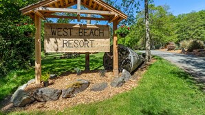A wooden sign for West Beach Resort with a pergola structure. - Garden Studio Cabin w/ peek-a-boo views - 1 min walk to beach! (Eastsound)