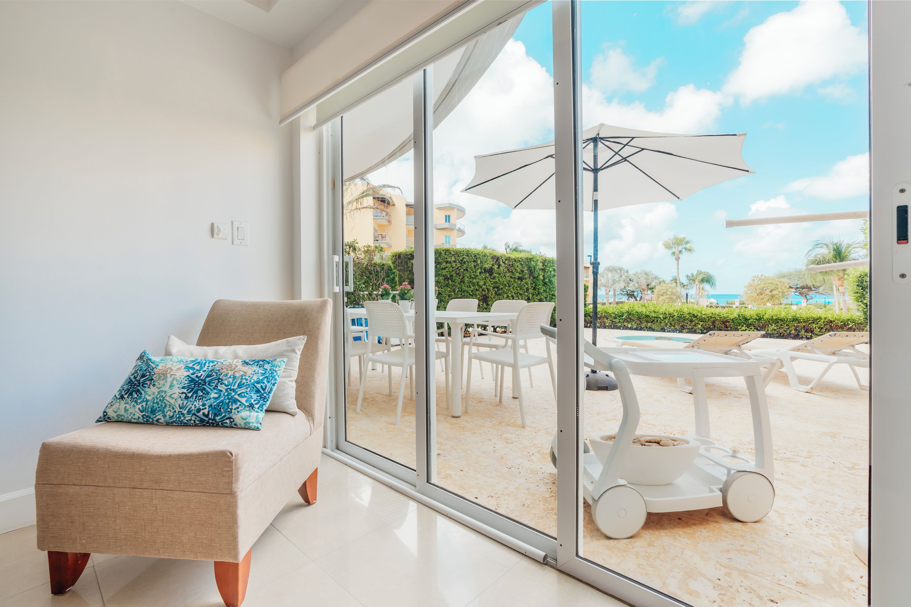 A modern living room with a sliding glass door leading to an outdoor patio area.