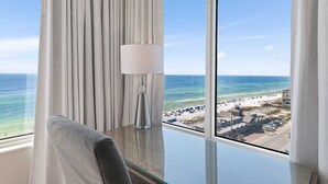 Ein Zimmer mit Blick auf den Strand, einer Lampe und einem Sessel.