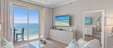 Un salón amplio con balcón, televisión de pantalla plana y diseño moderno.
