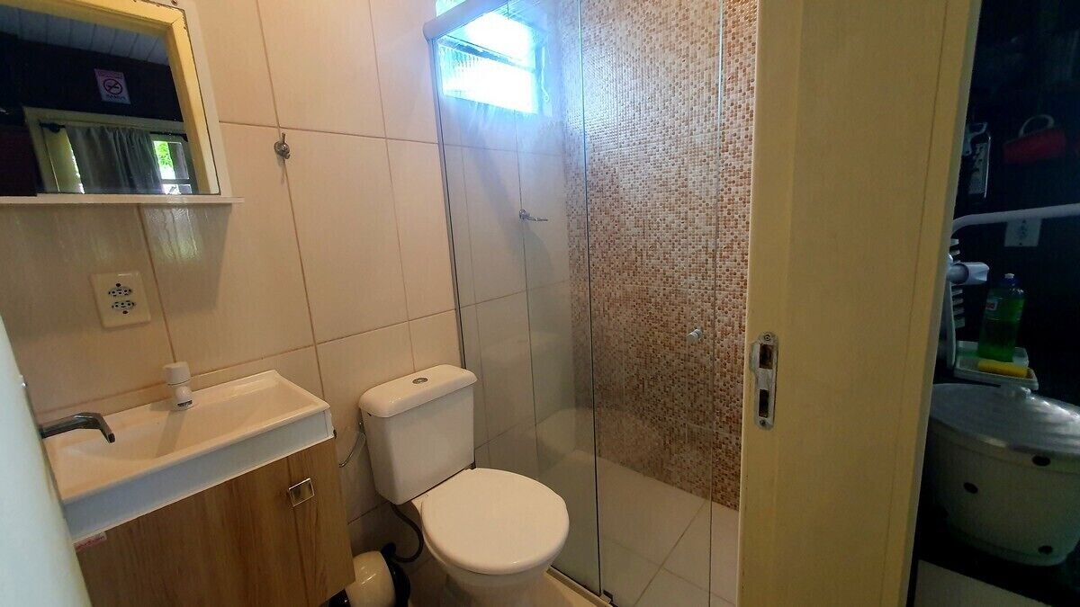 A bathroom with a toilet, sink, and shower.