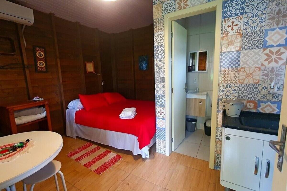 Une pièce comprenant un lit, une petite table, un lavabo et un placard.