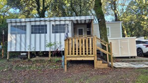 Eine kleine, einstöckige Holzhütte mit einer Holzterrasse und einigen Stufen, die zum Eingang führen.