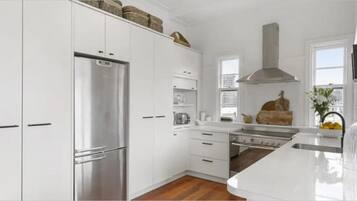 A modern kitchen with white cabinetry, stainless steel appliances, and a central island.