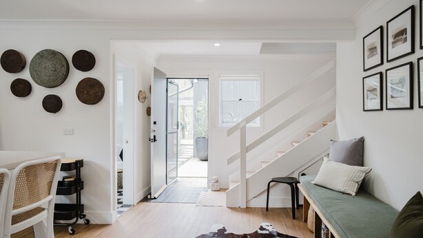 Un intérieur moderne avec un escalier, un canapé et un coin repas.