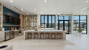 A modern kitchen with a central island, bar stools, and large windows. - Amazing Deluxe 2BR Pool/Gym/Htub (Salt Lake City)