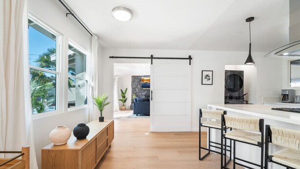 Una cocina moderna con barra, ventanas amplias y vistas al exterior.