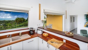 Eine moderne Küche mit großem Fenster, Holzarbeitsplatte und weißen Schränken.