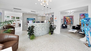 A modern reception area with a central counter, seating, and artwork. - Chic Hotel in Vibrant Miami with Free Pool, WiFi, Coffee and Bagels - BOOK NOW! (Miami)