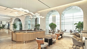 A modern lobby with a reception desk, seating area, and large arched windows. - The Link Seoul, A Tribute Portfolio Hotel (Seoul)