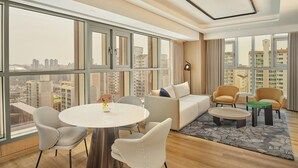 A modern hotel room with a large window, a round dining table, two chairs, a sofa, and a small coffee table. - The Link Seoul, A Tribute Portfolio Hotel (Seoul)