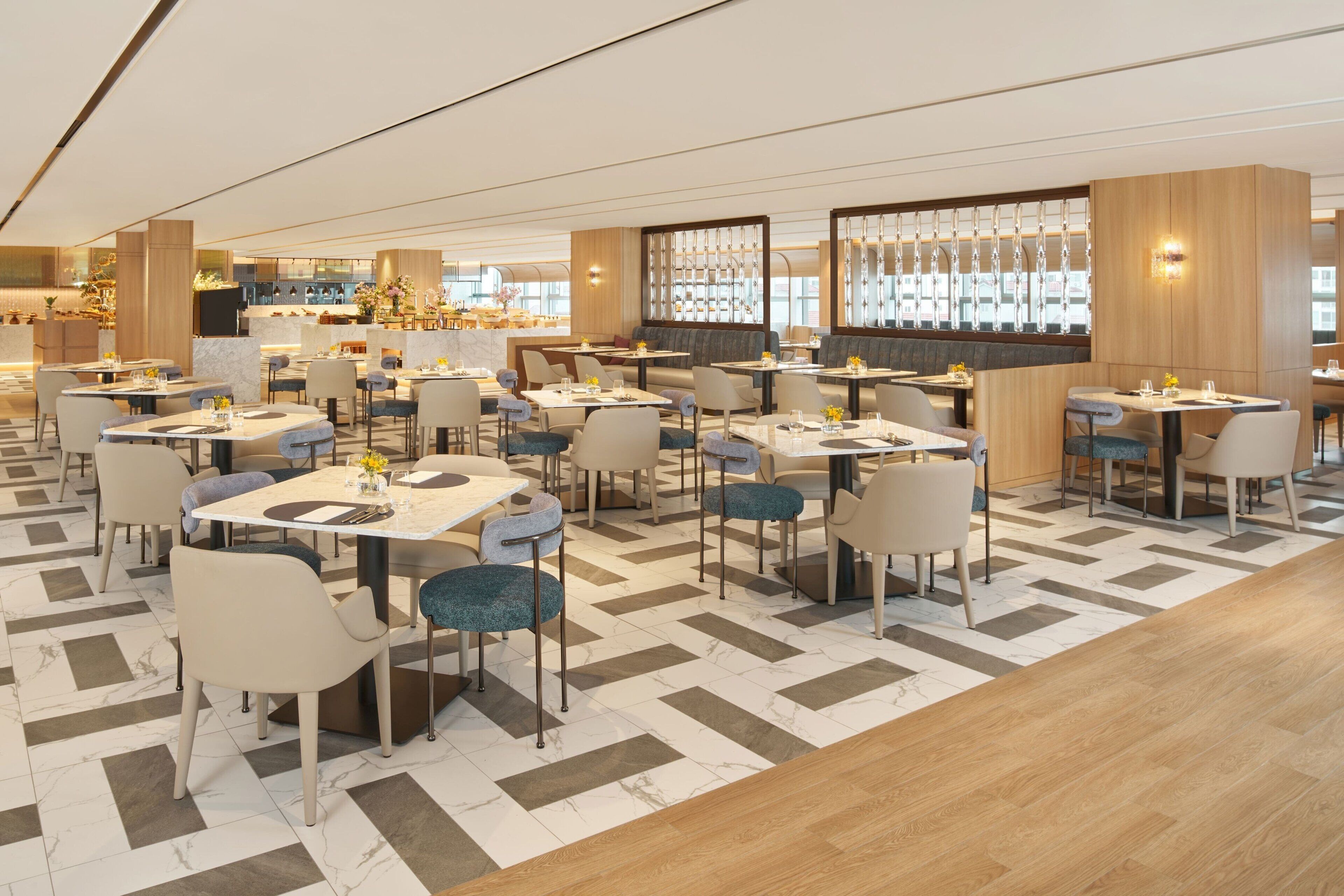 A modern restaurant with a variety of seating options, including tables and booths, arranged in a spacious layout with a patterned floor.