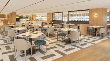 A modern restaurant with a variety of seating options, including tables and booths, arranged in a spacious layout with a patterned floor.