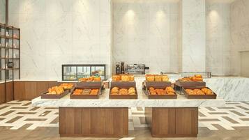 A breakfast buffet with various pastries and bread, marble walls, and wooden cabinets.