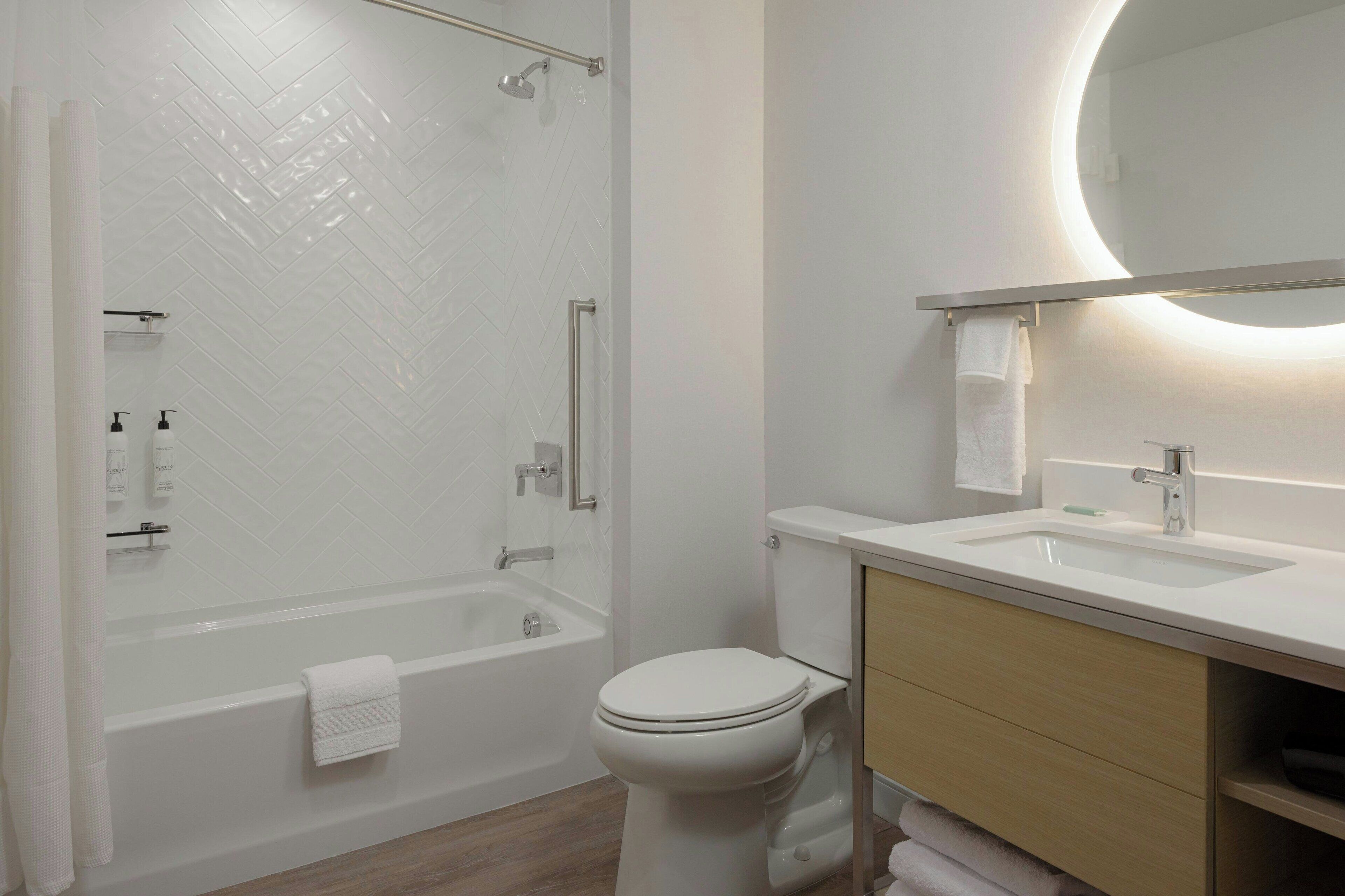 Un baño moderno con ducha, inodoro y lavamanos.