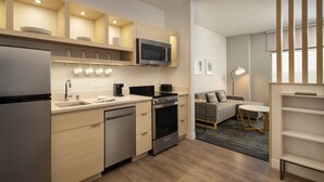 Una cocina moderna con electrodomésticos de acero inoxidable, armarios de madera y un microondas integrado.