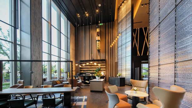 Un intérieur moderne avec de grandes fenêtres, un espace bar et différents types de sièges.