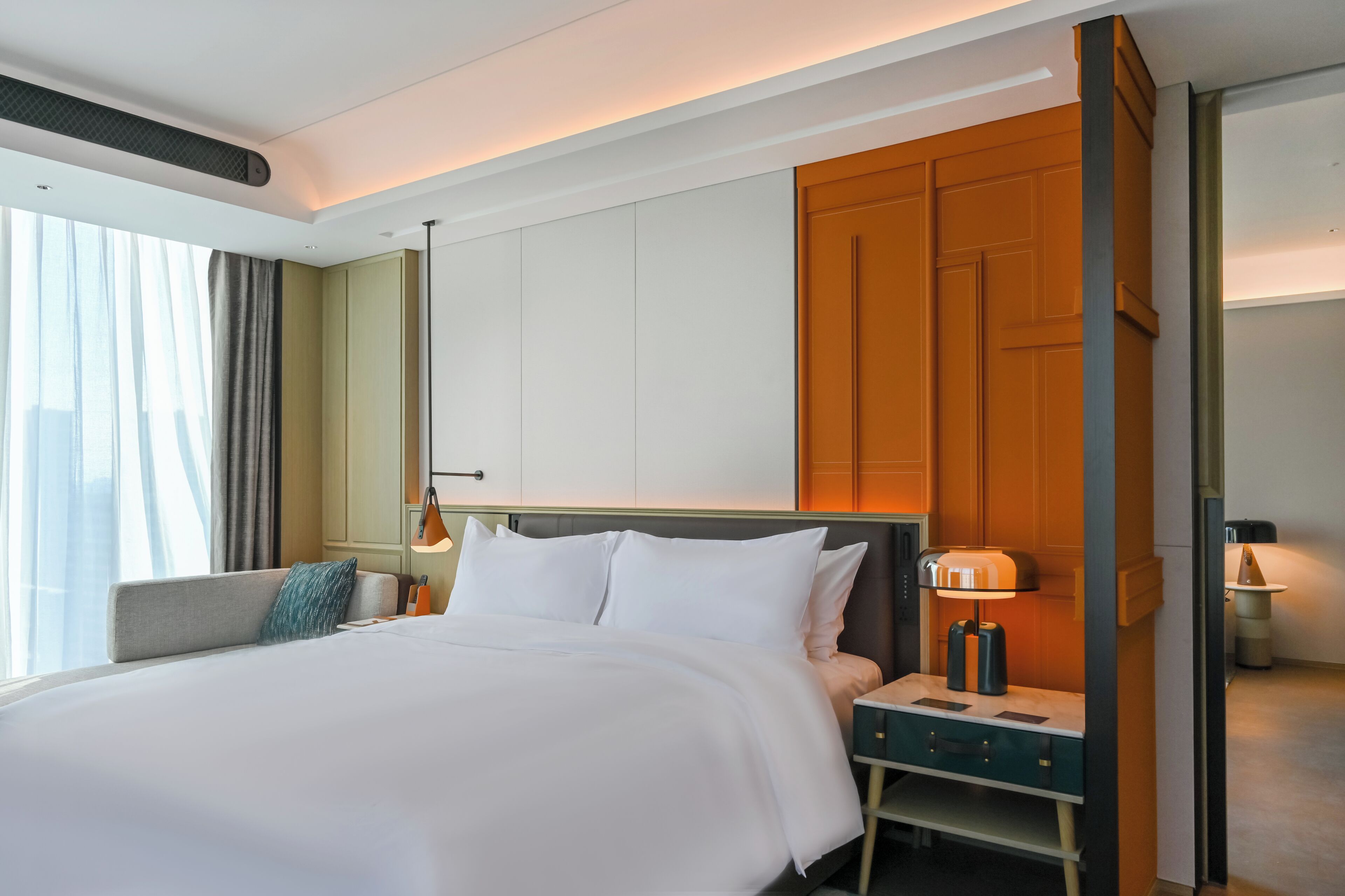 Een hotelkamer met een groot bed, nachtkastjes, een bureau en een kledingkast.