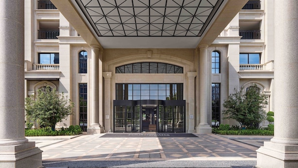A grand entrance with a fountain, large columns, and a glass door entrance.