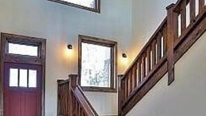 A wooden staircase with a handrail leading to a landing. - Above It all (Lake Arrowhead)