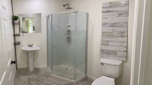 A bathroom with a glass shower enclosure, a pedestal sink, and a toilet. - Elenem Resort (Magalang)