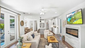 A spacious living room with a sofa, armchairs, a coffee table, and a fireplace.