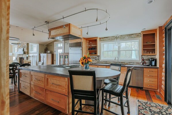A spacious kitchen with a large island, wooden cabinets, and a built-in oven.