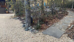 A gravel driveway leading to a stone pathway.