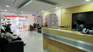 Et receptionsområde med reception, et venteområde med stole og et synligt skilt til udgang.