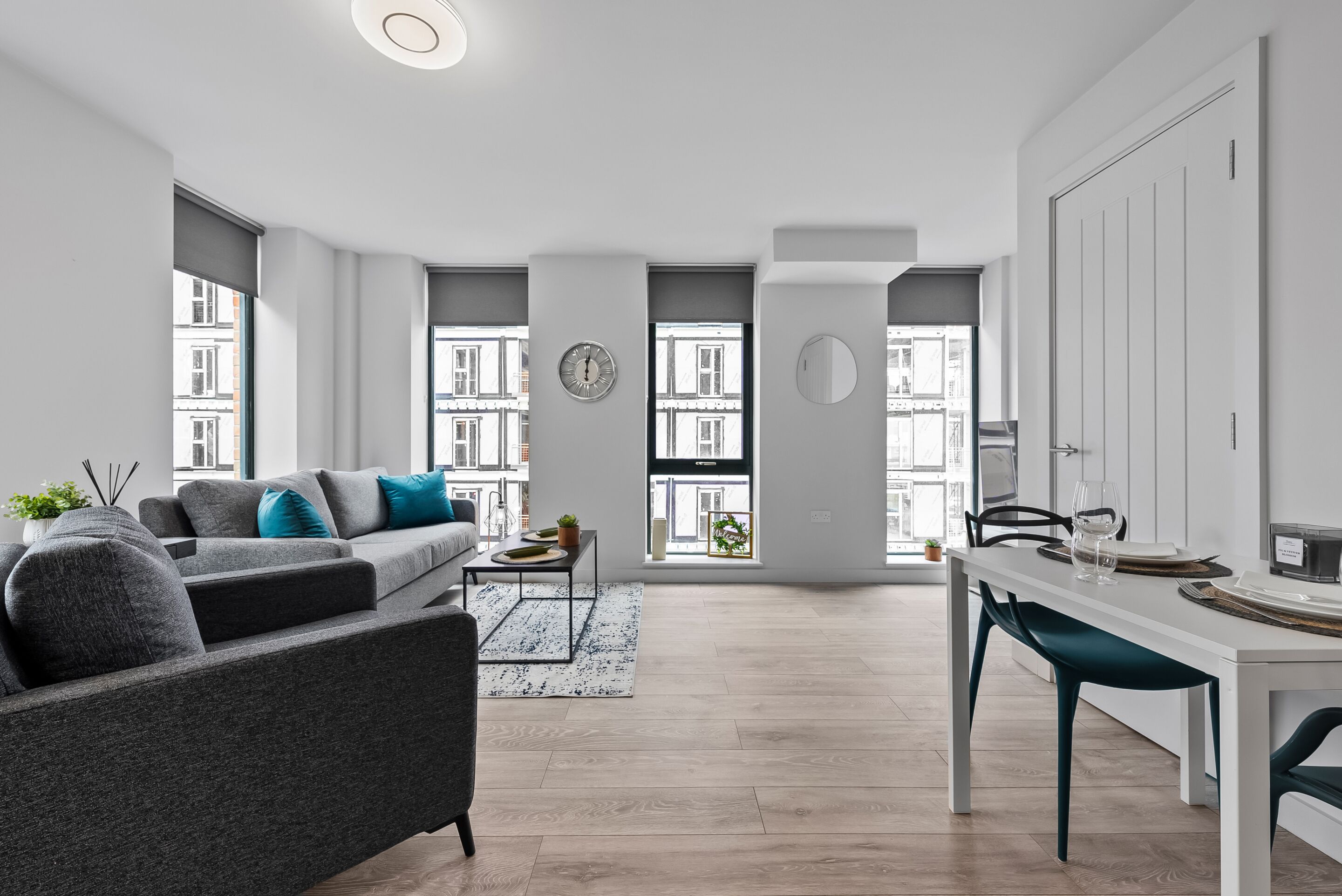 A modern living room with a sofa, coffee table, and dining area.